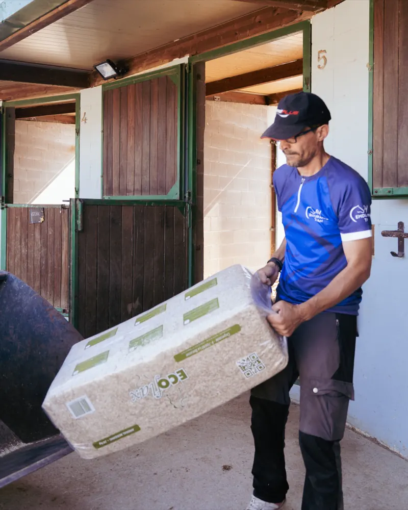Carlos carrying Ecoflax bedding at the yard
