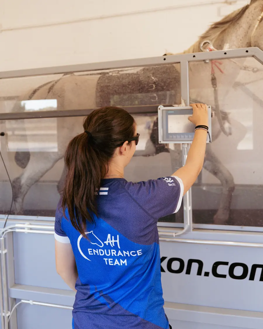 Bárbara adjusting the water treadmill settings during a session